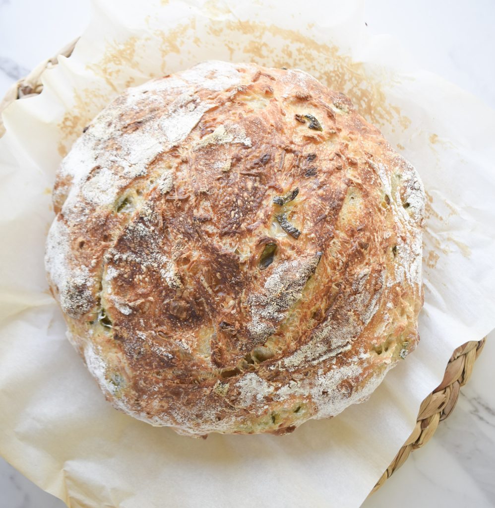 Jalapeño cheddar sourdough boule on parchment paper