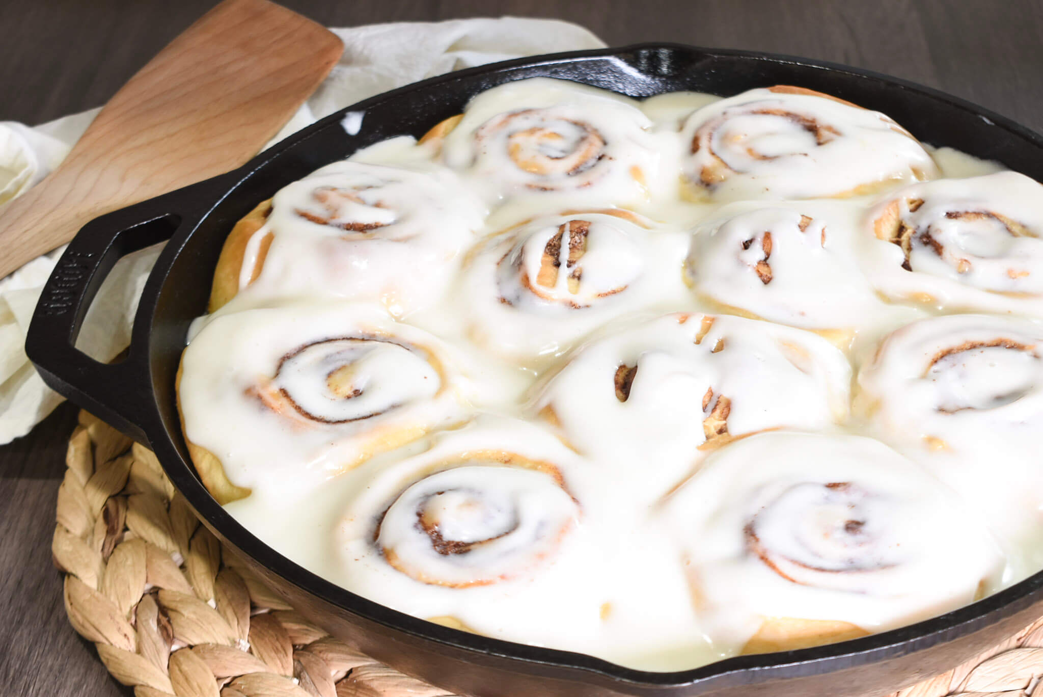 Glazed sourdough cinnamon rolls in a cast iron skillet