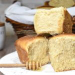 Sourdough Milk Brioche Rolls on a plate with honey jar