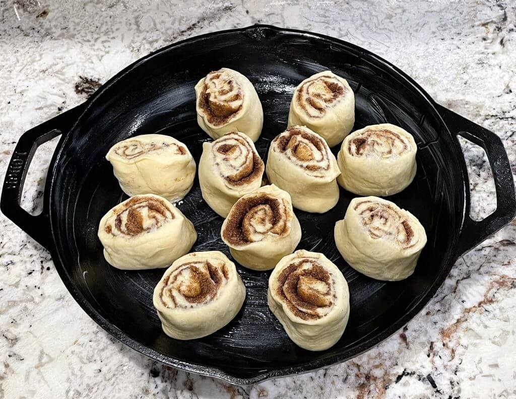 Unbaked sourdough cinnamon rolls in a cast iron skillet