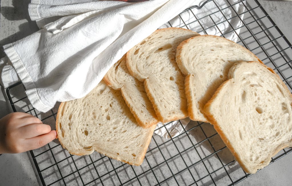 Soft sourdough sandwich bread on a cooling rack